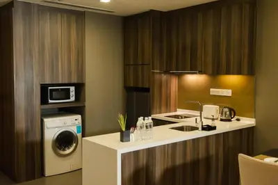 a kitchen with a washing machine and a washer at Ramada Suites by Wyndham Kuala Lumpur City Centre in Kuala Lumpur