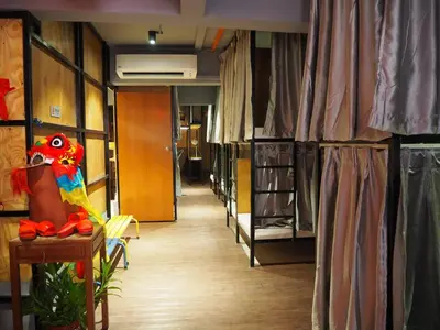 a corridor of a room with bunk beds and a parrot on a table at Leo Leisure Hotel @ Central Market in Kuala Lumpur