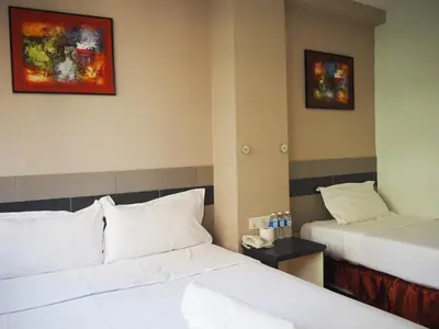a hotel room with two beds and paintings on the wall at Leo Leisure Hotel @ Central Market in Kuala Lumpur