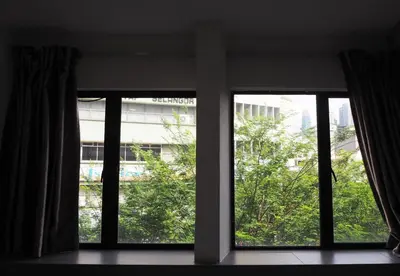 two windows in a room with a view of a building at Leo Leisure Hotel @ Central Market in Kuala Lumpur