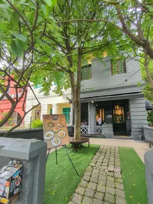 a bench in front of a building with a tree at Cozy Place-Rumah Nyaman - Bukit Bintang by Shine Stay in Kuala Lumpur
