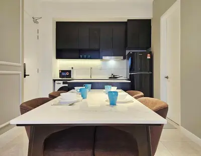 a kitchen with a white table and some blue cups at Axon Suite Bukit Bintang 3Bed Room Suites ,5min Pavillion KL in Kuala Lumpur