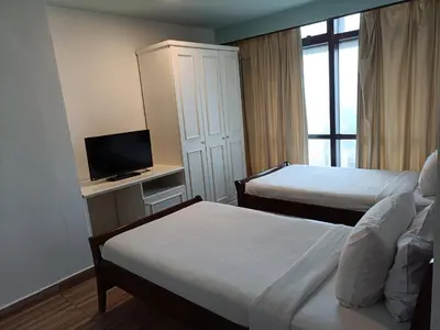 a hotel room with two beds and a television at Times Square Apartment By Skyline in Kuala Lumpur
