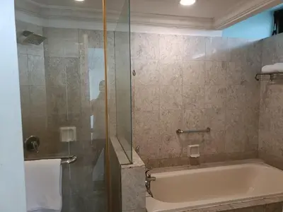 a bathroom with a tub and a glass shower at Times Square Apartment By Skyline in Kuala Lumpur