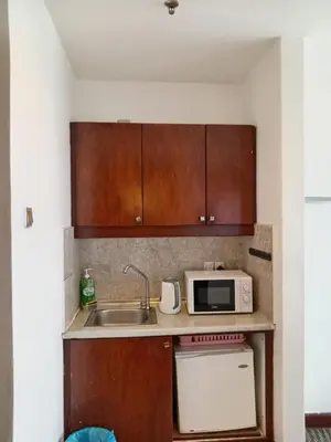 a small kitchen with a sink and a microwave at Times Square Apartment By Skyline in Kuala Lumpur