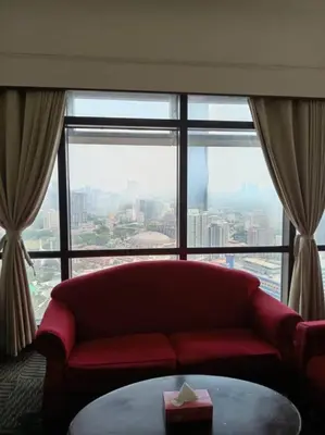 a red couch in a room with a large window at Times Square Apartment By Skyline in Kuala Lumpur