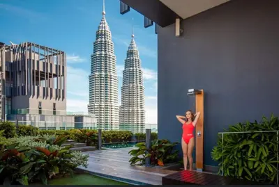 a woman in a red dress standing next to a building at Star Residence Pool View 2br Unit Floor 8 in Kuala Lumpur