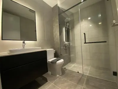 a bathroom with a toilet and a glass shower at The Axon Bukit Bintang Residence by De Space in Kuala Lumpur