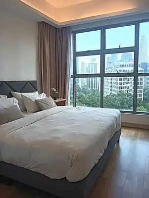 a bedroom with a large bed with a large window at Suasana Suites KLCC Bukit Ceylon in Kuala Lumpur