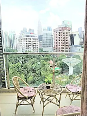 a balcony with a table and chairs and a view of a city at Suasana Suites KLCC Bukit Ceylon in Kuala Lumpur