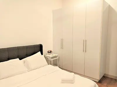 a bedroom with white cabinets and a bed at Suasana Suites KLCC Bukit Ceylon in Kuala Lumpur