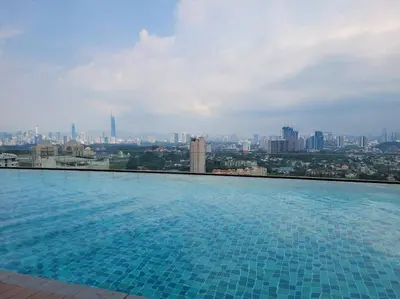 a large swimming pool with a view of a city at OOAK Residence at Mont Kiara in Kuala Lumpur