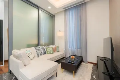 a living room with a white couch and a tv at Royce Residence KLCC by Cobnb in Kuala Lumpur
