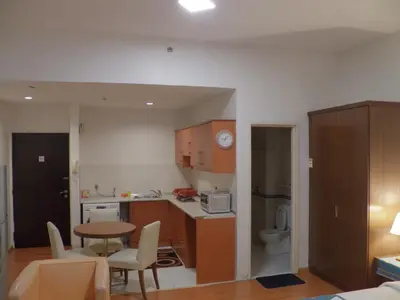 a small kitchen with a table and a dining room at Maytower Apartment in Kuala Lumpur