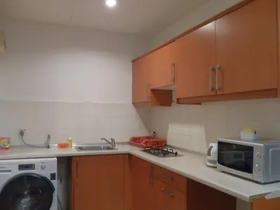 a kitchen with a sink and a microwave at Maytower Apartment in Kuala Lumpur