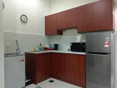 a kitchen with a refrigerator and a clock on the wall at Maytower Apartment in Kuala Lumpur