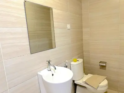 a bathroom with a sink and a toilet and a mirror at 3 Towers Jalan Ampang By Serenity Vacation Homes in Kuala Lumpur