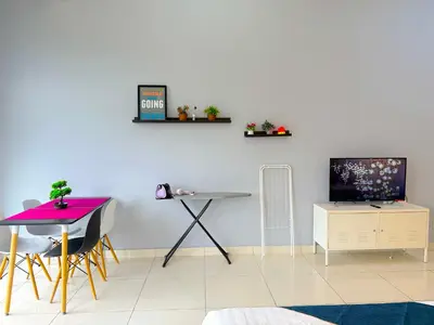 a living room with a table and a tv at 3 Towers Jalan Ampang By Serenity Vacation Homes in Kuala Lumpur