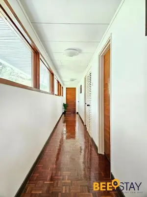 a hallway with white walls and wood floors and windows at Bangsar Three Storey Luxury Landed House 19PAX in Kuala Lumpur