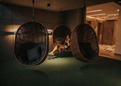 a woman sitting in three hanging chairs in a room at Ceylonz Suite Kuala Lumpur Bukit Bintang in Kuala Lumpur