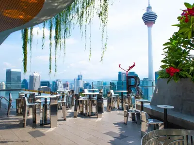 a patio with tables and chairs and a view of the city at Ceylonz Suite Kuala Lumpur Bukit Bintang in Kuala Lumpur