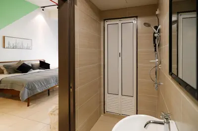 a bathroom with a shower and a bed in a room at 3Towers @ KL City Centre in Kuala Lumpur