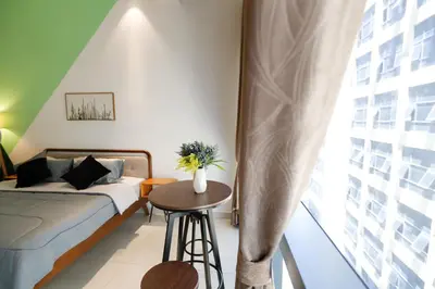 a bedroom with a bed and a table and a window at 3Towers @ KL City Centre in Kuala Lumpur