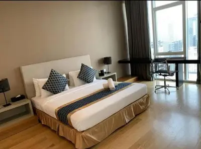 a bedroom with a large bed and a table at The Platinum KLCC By Victoria Home in Kuala Lumpur