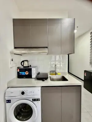 a kitchen with a washing machine and a sink at Neu Suites Service Apartment in Kuala Lumpur