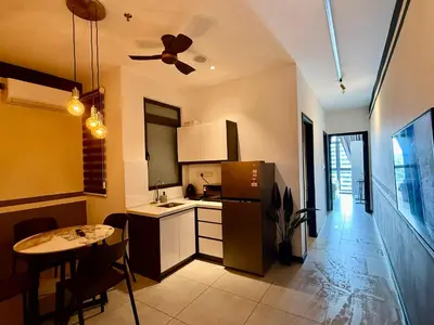 a kitchen with a small table and a refrigerator at Neu Suites Service Apartment in Kuala Lumpur