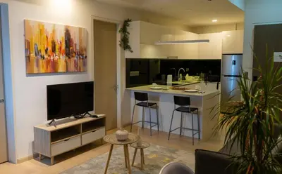 a living room with a kitchen with a tv at Star Residence Klcc By M&T in Kuala Lumpur