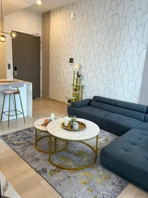 a living room with a blue couch and a table at Star Residence Klcc By M&T in Kuala Lumpur