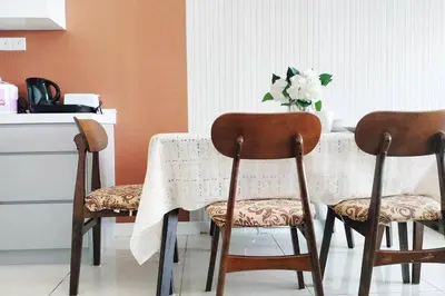 a table with three chairs and a vase of flowers at Central KL Retreat MyTown Ikea KLCC TRX Mall MRT in Kuala Lumpur