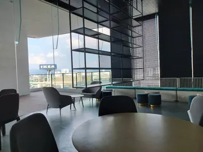 a room with tables and chairs and a large window at Central KL Retreat MyTown Ikea KLCC TRX Mall MRT in Kuala Lumpur