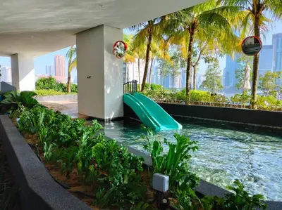 a water slide in a swimming pool with palm trees at Central KL Retreat MyTown Ikea KLCC TRX Mall MRT in Kuala Lumpur