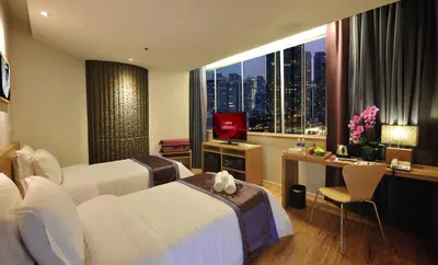 a hotel room with a bed and a desk and a window at de King Hotel KLCC in Kuala Lumpur