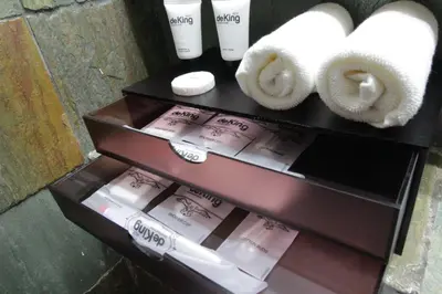a shelf with three rolls of toilet paper and towels at de King Hotel KLCC in Kuala Lumpur