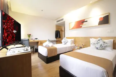 a hotel room with two beds and a flat screen tv at de King Hotel KLCC in Kuala Lumpur