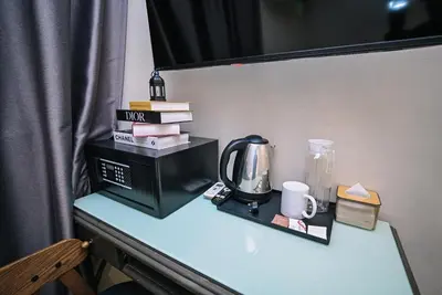 a table with a microwave and books on it at Kingston Hotel 6 - Changkat, Bukit Bintang in Kuala Lumpur