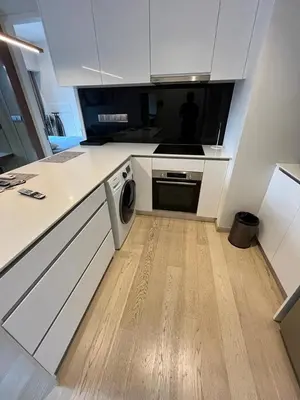 a kitchen with white cabinets and a washing machine in it at Star Residence KlCC By M&T in Kuala Lumpur