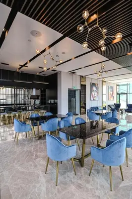 a dining room with blue chairs and tables at Star Residence KlCC By M&T in Kuala Lumpur