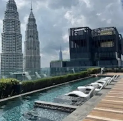 a row of white chairs in front of tall buildings at Star Residence KlCC By M&T in Kuala Lumpur
