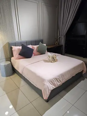 a bed with pink and blue pillows on it at Anggun Arte Mont Kiara in Kuala Lumpur