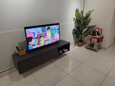 a living room with a flat screen tv on a cabinet at Anggun Arte Mont Kiara in Kuala Lumpur