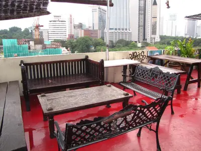 a patio with benches and tables on a roof at Oasis Guest House in Kuala Lumpur
