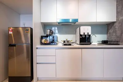 a kitchen with white cabinets and a refrigerator at Duplex Industrial Loft 5pax above Eko Cheras Mall in Kuala Lumpur