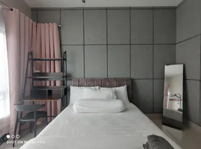 a bedroom with a large bed and a chair at HaNi Homestay KL in Kuala Lumpur