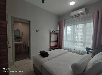 a bedroom with a bed and a bathroom with a window at HaNi Homestay KL in Kuala Lumpur