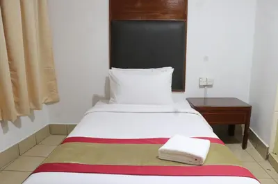 a small bedroom with a bed and a table at Hotel Seri Putra in Kuala Lumpur