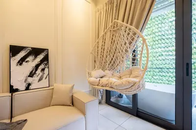 a swinging chair in a living room with a window at The Element Ampang in Kuala Lumpur